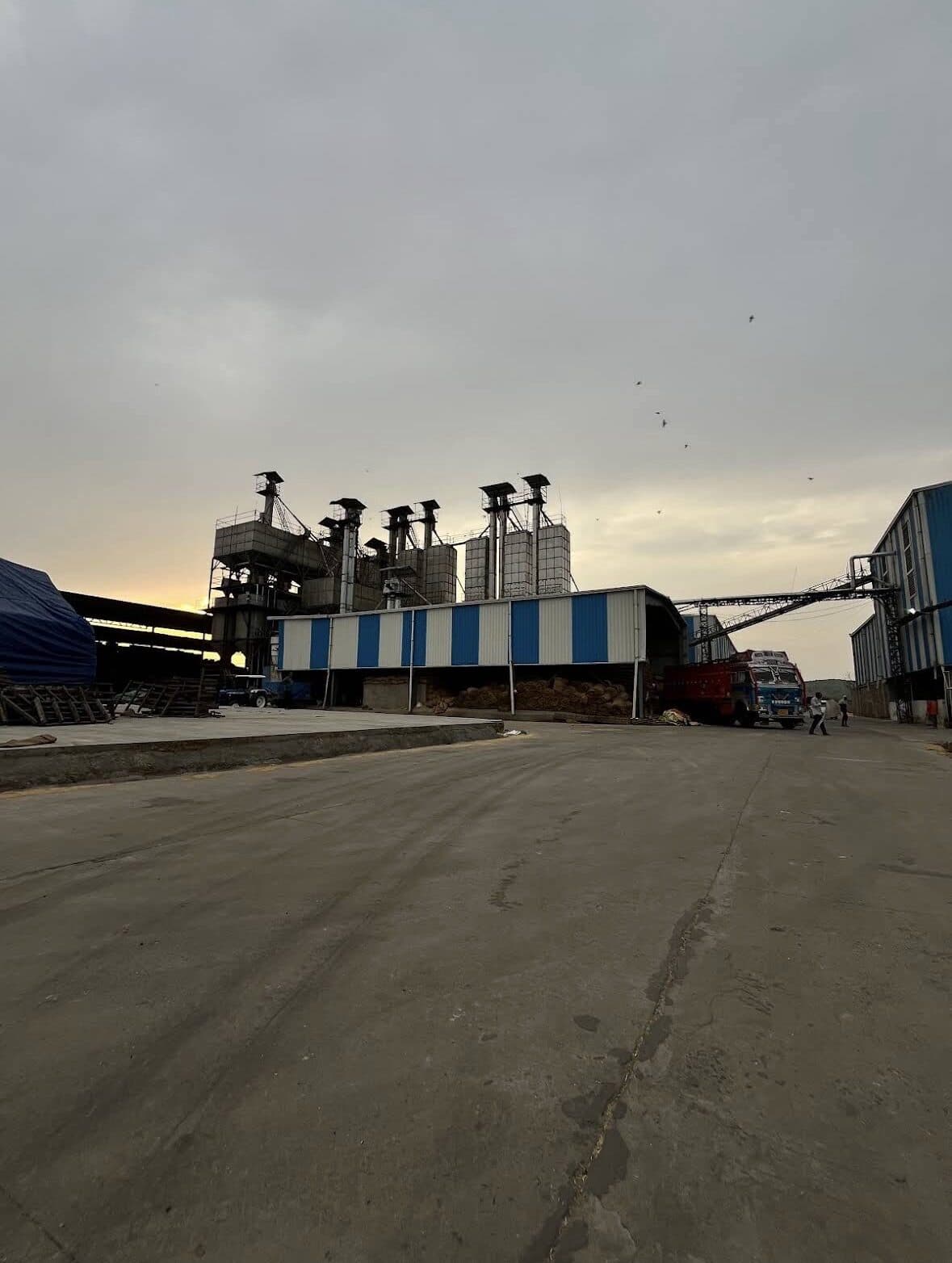A loaded truck beside the mill shed at dusk
